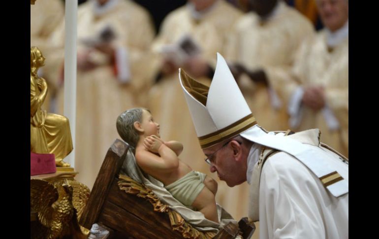 El Papa Francisco besa al bebé Jesús durante la misa de Nochebuena para celebrar el nacimiento de Jesucristo. AP / A. Pizzoli