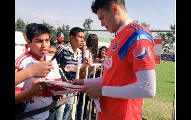 Jugadores de Chivas firman camisetas a seguidores del equipo luego del entrenamiento. TWITTER / ‏@Chivas