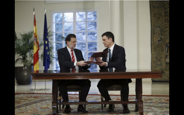 El presidente del gobierno Mariano Rajoy (I) y el líder del opositor Partido Socialista Pedro Sánchez (D) firman el acuerdo. EFE / F. Alvarado