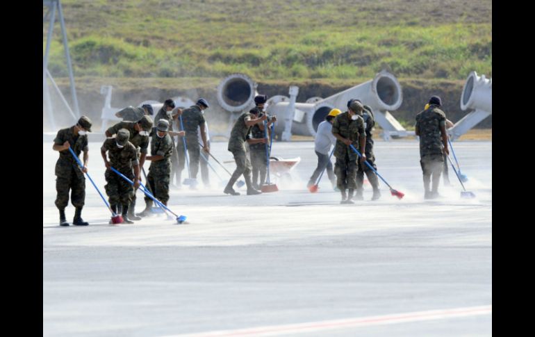 Cerca de 100 soldados participaron en las operaciones de limpieza barriendo la pista del aeropuerto. AFP / J. Ordonez