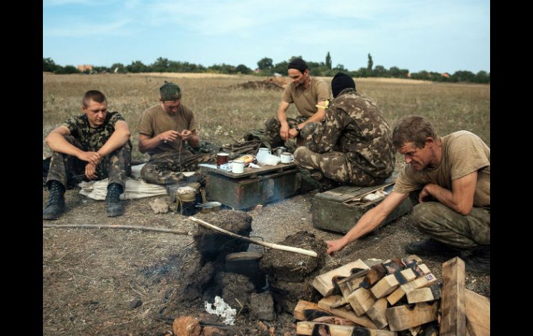 Soldados ucranianos se preparan una comida en una fogata en su campamento militar. EFE / ARCHIVO