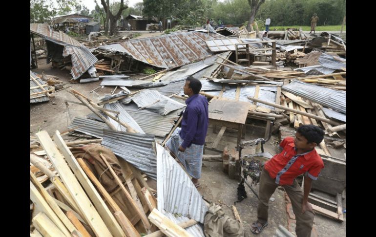 Algunos hombres revisan los restos de sus viviendas tras el paso de la fuerte tormenta en Gabtoli, Bangladesh. AP / S. Islam