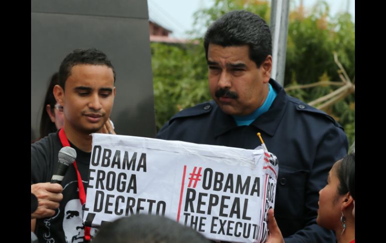 El presidente venezolano sostiene una caja que dice 'Obama deroga el decreto ya', en alusión a que Venezuela representa una amenaza. AP / R. Espinosa