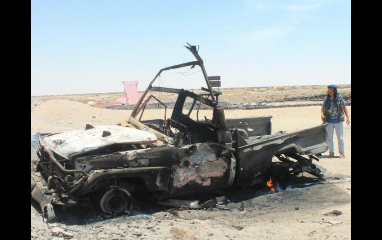 Un hombre permanece junto a los restos de un vehículo tras un ataque aéreo contra los rebeldes. AP / S. Al-Obeidi