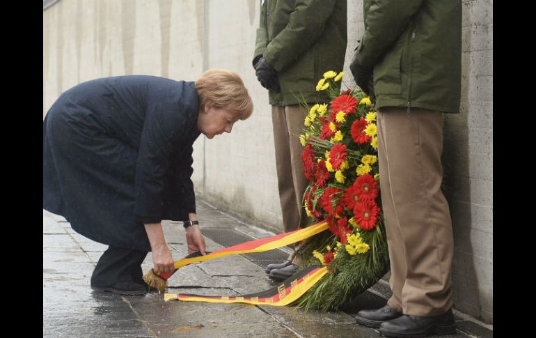Angela Merkel extiende arreglo floral frente al campo de concentración de Dachau. EFE / A. Gerbert