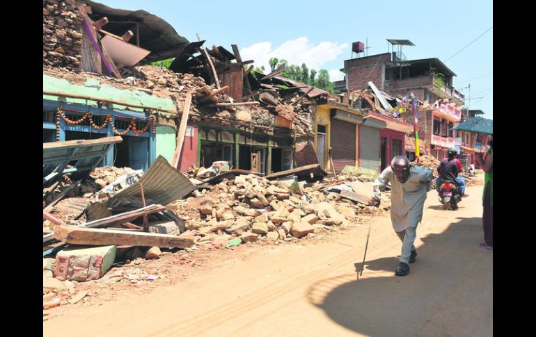 Ruinas. Pobladores recorren una calle devastada por el fenómeno del 25 de abril. AFP /