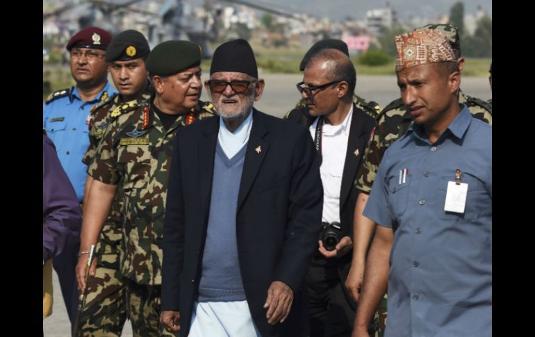 Suchil Koirala (centro), primer ministro de Nepal, tras haber abordado el helicóptero que lo llevó a las áreas devastadas en el norte. AFP / R. Schmidt