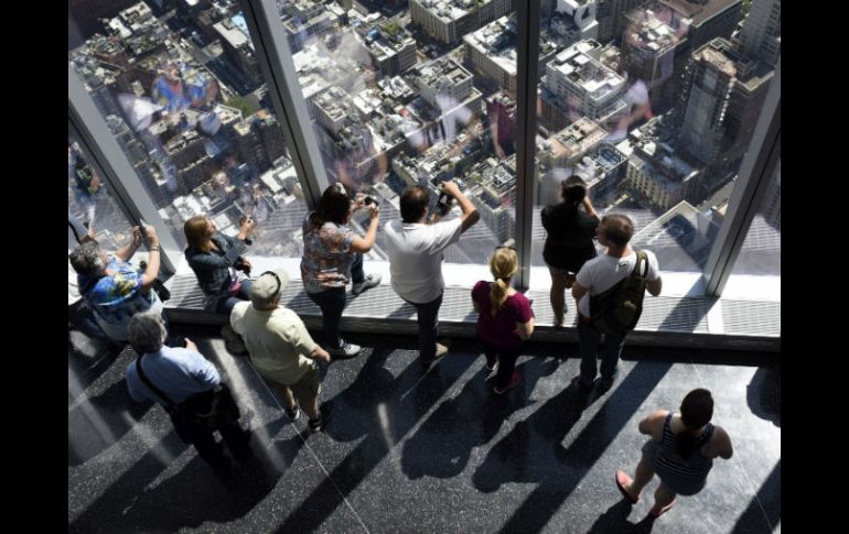 Varias personas observan las vistas desde el nuevo observatorio del edificio One World Trade Center de Nueva York. EFE / J. Lane