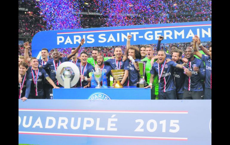 El plantel del PSG posa con los trofeos (de izq. a der.) de la Ligue 1, la Coupe de France,la Supercopa francesa y la Copa de la Liga. AP / J. Brinon