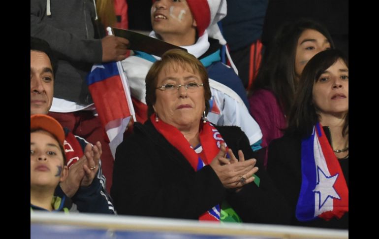 La mandataria llega al recito deportivo con una bufanda alusiva a la selección chilena. AFP / R. Arangua