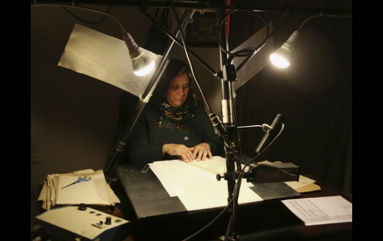 En cuartos oscuros en los fondos de la biblioteca, los expertos utilizan iluminación especial para fotografiar los documentos. AP / K. Kadim