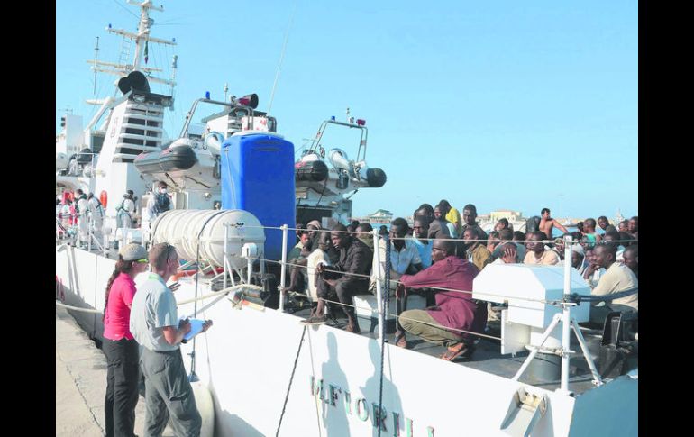 ITALIA. Algunos de los 250 inmigrantes rescatados en el Mar Mediterráneo desembarcan de una nave de la Guardia Costera italiana. AFP /