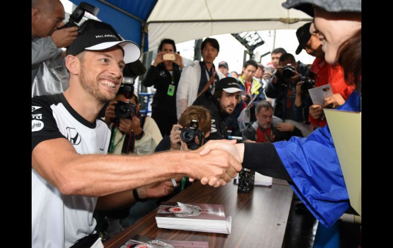 El piloto británico Jenson Button, de McLaren, reparte autógrafos entre sus fans en el circuito de Suzuka. AFP / T. Yamanaka