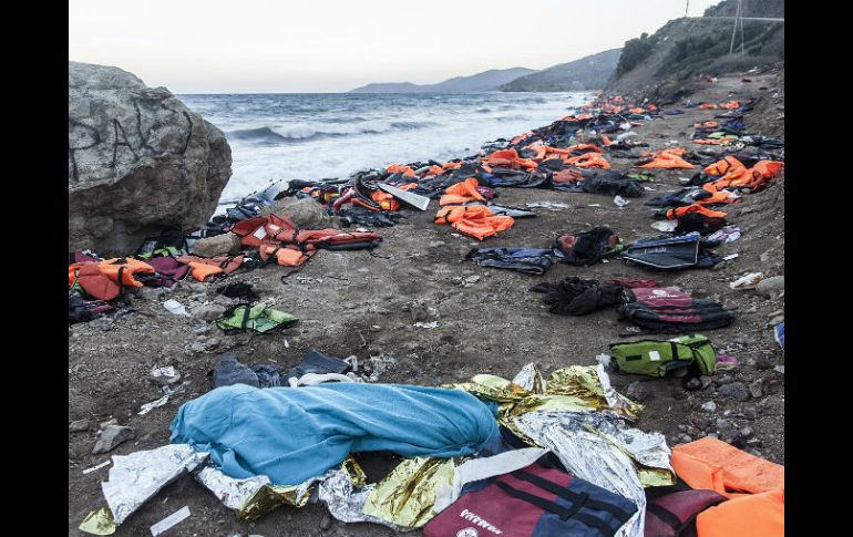El cadaver de una persona yace junto a las chaquetas salvavidas luego de un naufracio acaecido en aguas griegas. EFE / S. Donaire