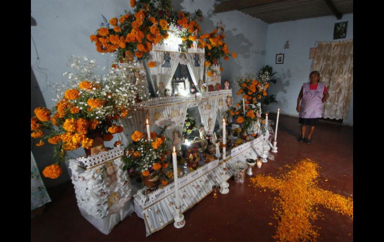 Veladoras, cirios, juguetes y flores, además de alimentos, adornan los altares de muertos. NTX / C. Pacheco