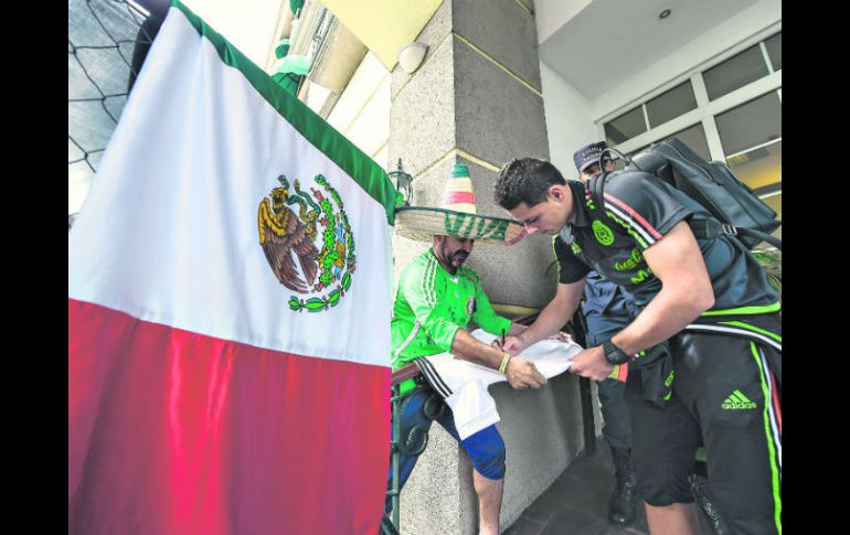 El delantero Javier Hernández atiende a un aficionado mexicano en el hotel de concentración de México en San Pedro Sula. MEXSPORT / E. Espinosa