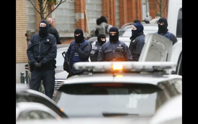 Agentes de policía antidisturbios permanecen en guardia en el distrito de Molenbeek en Bruselas mientras se realiza un cateo. EFE / O.Hoslet