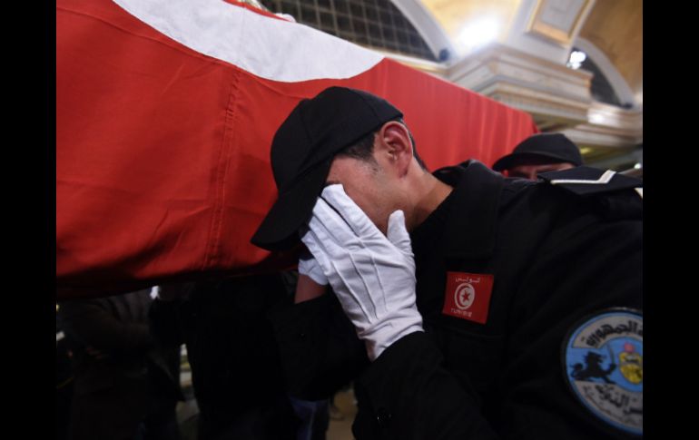 Un agente de policía llora junto al atúd de un guardia presidencial muerto por el acto terrorista. AFP / F. Belaid