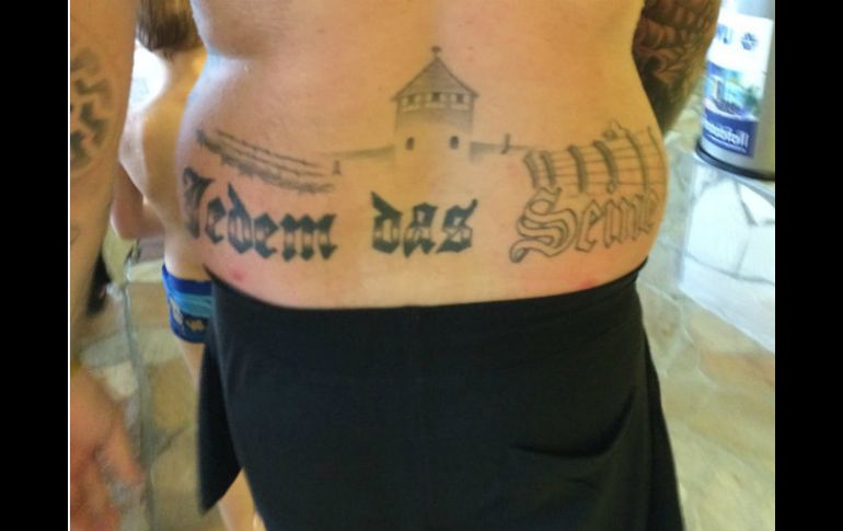 Un hombre viola la prohibición del país al exhibir públicamente símbolos nazis con un tatuaje del campo de concentración Auschwitz. AP / A. Marguier