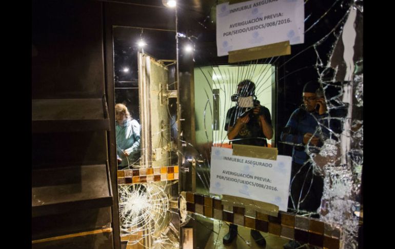 El muro de espejo que ocultaba el túnel quedó con huellas de disparos y parcialmente destruido. AFP / H. Guerrero