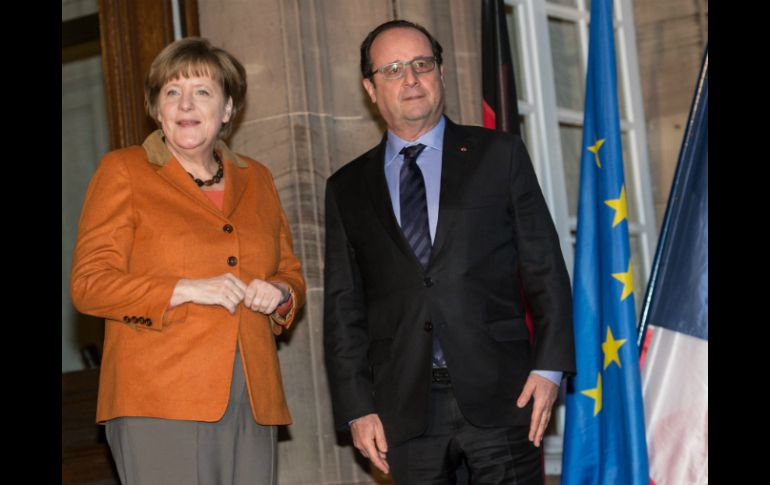Antes del comienzo, Hollande y Merkel se estrecharon la mano y posaron brevemente ante los medios. EFE / P. Seeger