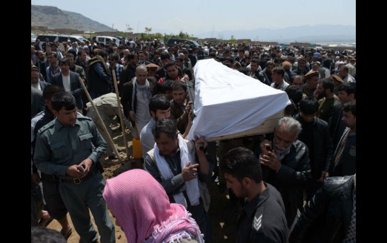 Varias personas participan en el funeral de una de las víctimas mortales del ataque de ayer. AFP / S. Marai