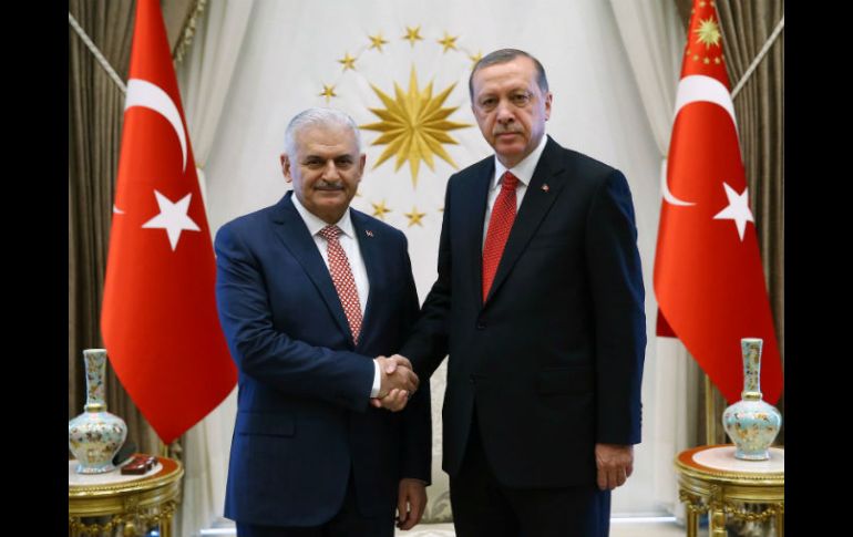 El presidente turco, Recep Tayyip Erdogan, estrecha la mano del primer ministro, Binali Yildirim. AFP / H. Ozer