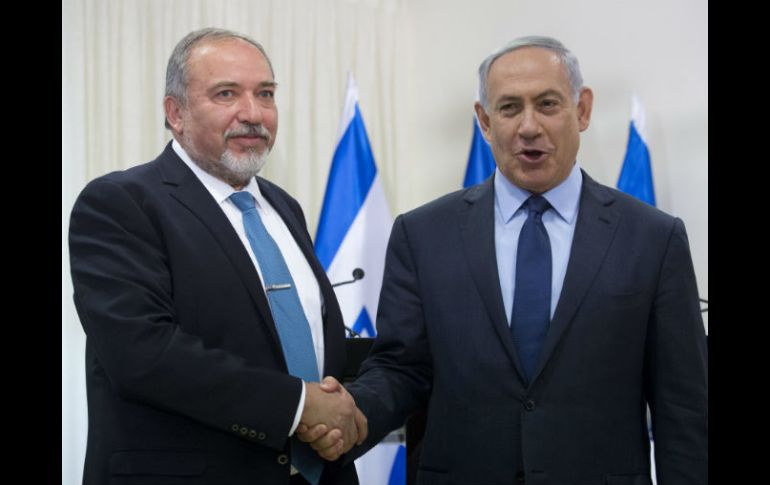 Benjamin Netanyahu (d) estrecha la mano de Avigdor Lieberman, ahora minsitro de Defensa. EFE / A. Sultan