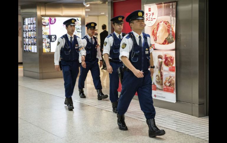 Policías vigilan una estación de tren; más de 19 mil agentes están dispersos por distintos puntos de Tokio. EFE / C. Jue