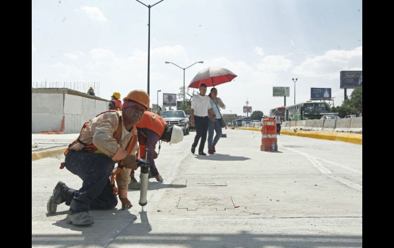 Trabajadores hacen los arreglos finales a los carriles laterales. EL INFORMADOR / E. Barrera