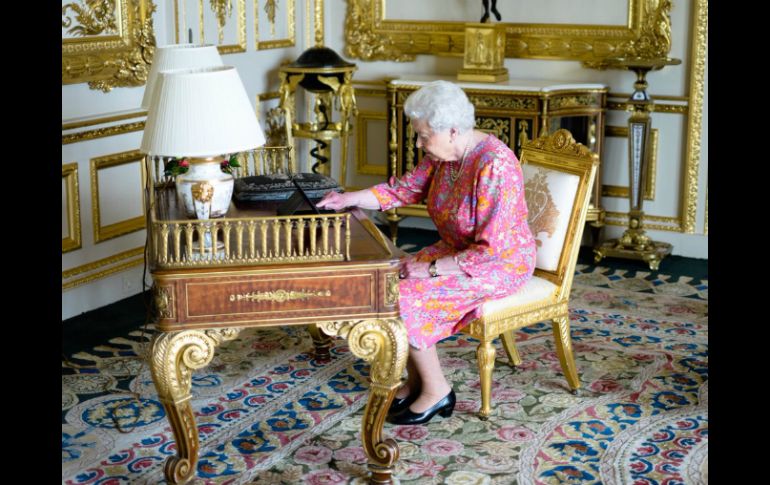 En la instantánea se ve a la monarca en una mesa de una de las salas del castillo de Windsor ataviada con un vestido rosa. TWITTER / @RoyalFamily