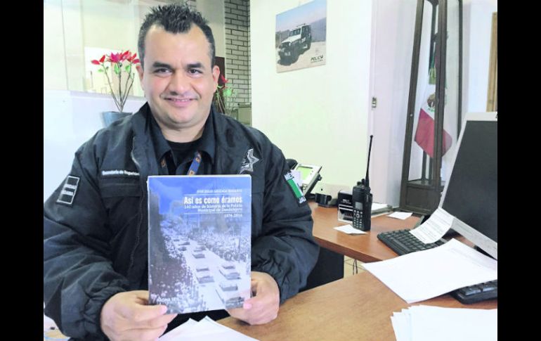 El oficial José Julio Arizaga Rodarte muestra el libro en el que narra la conformación de la Comisaría de Guadalajara. ESPECIAL /