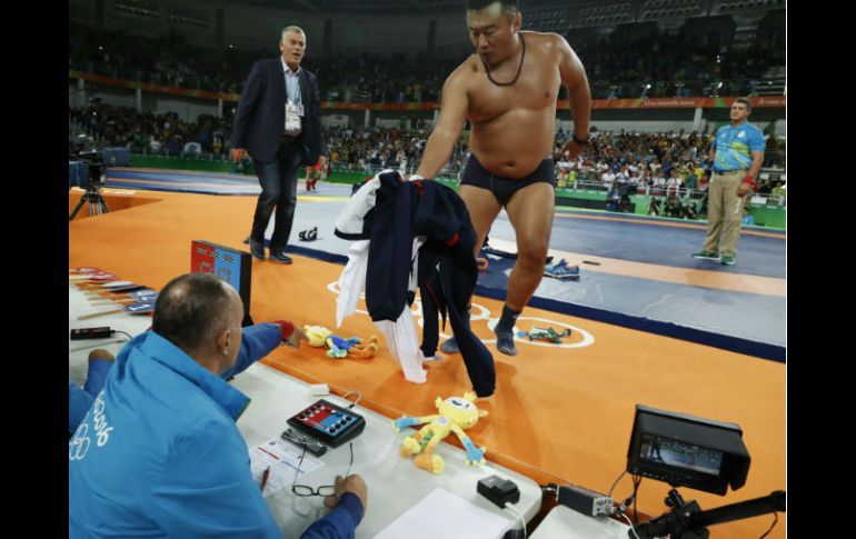 Uno de los entrenadores sube al ring y se quita los pantalones en protesta contra la decisión de los jueces. AFP / J. Guez