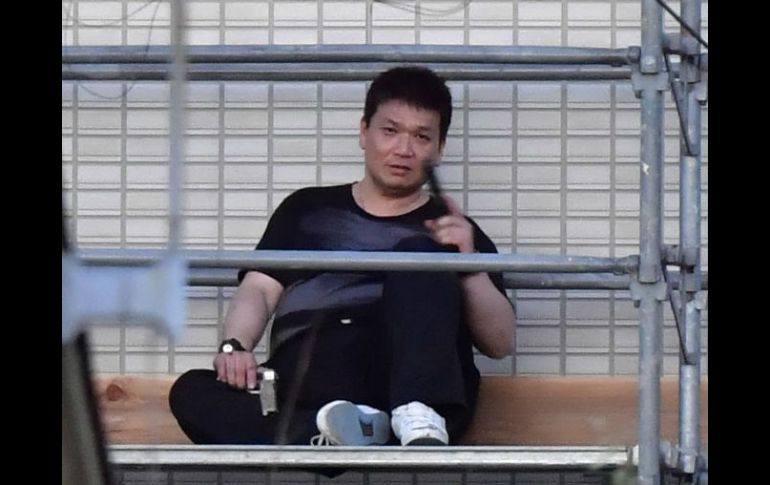 Medios nipones divulgaron imágenes de Mizobata vestido de negro, con un arma en cada mano y visiblemente cansado. AP / Kyodo News