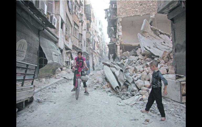 Dos menores van por una calle de Karm al-Jabal, destruido por los ataques armados. AFP /