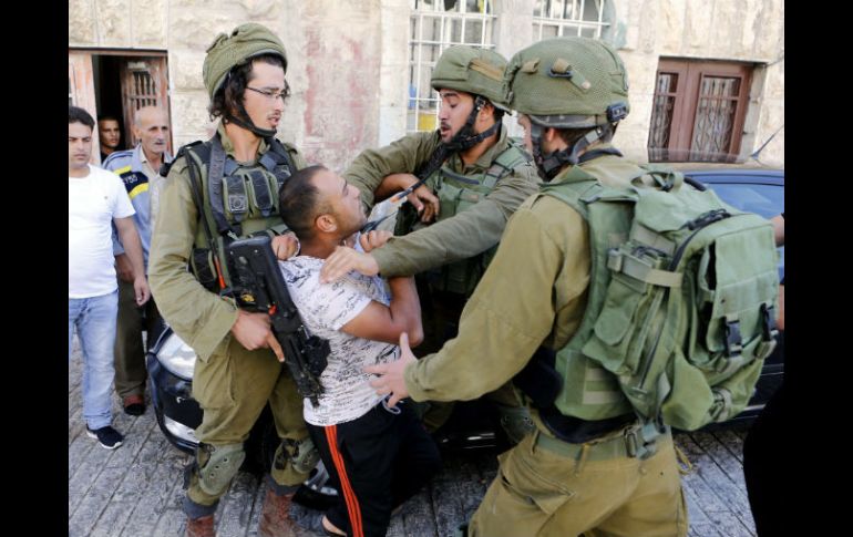 Soldados israelíes detienen a un ciudadano palestino durante un enfrentamiento en Hebrón. EFE / A. Al Hashlamoun