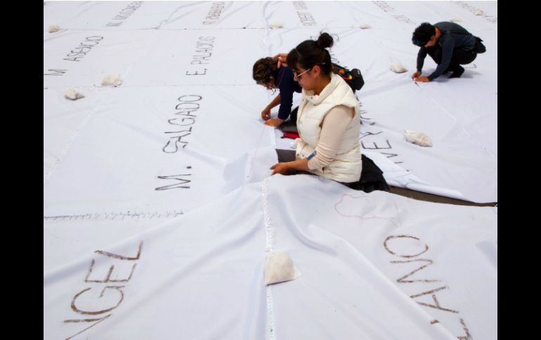 Los nombres fueron grabados con ceniza sobre cuadros de tela blanca unidos con hilos de colores. AFP / J. M. Gomez