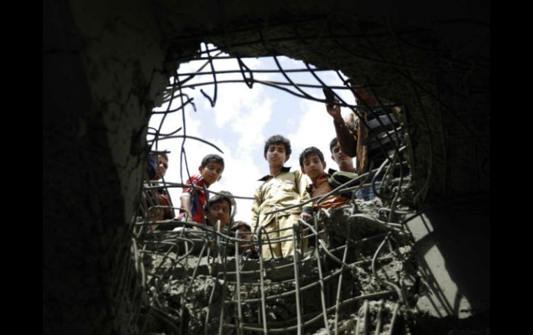 Un grupo de niños observa un hoyo que dejó una agresión saudí. AP / H. Mohammed