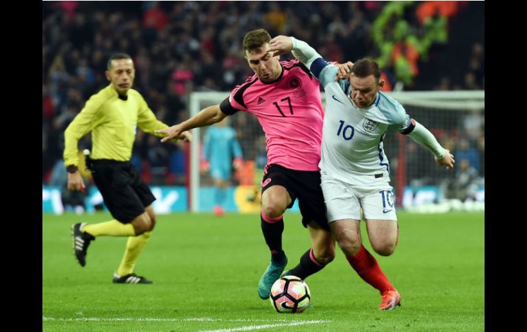 Rooney (D), disputa un balón con McArthur, (I) de Escocia. EFE / A. Rain
