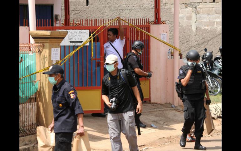 Policías hacen guardia afuera de la casa donde se hallaron los explosivos. AFP / B. Mahameru