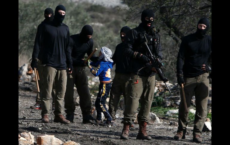 Soldados israelíes detienen brevemente a un niño después de una manifestación contra la expropiación de tierras palestinas. AFP / J. Ashtiyeh
