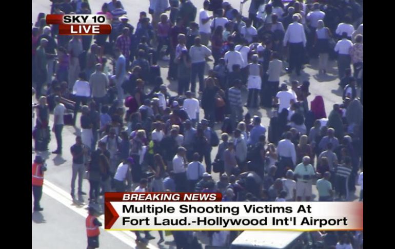 En esta imagen de televisión de NBC TV Local10 se observa a pasajeros siendo desalojados de la terminal aérea. AP /