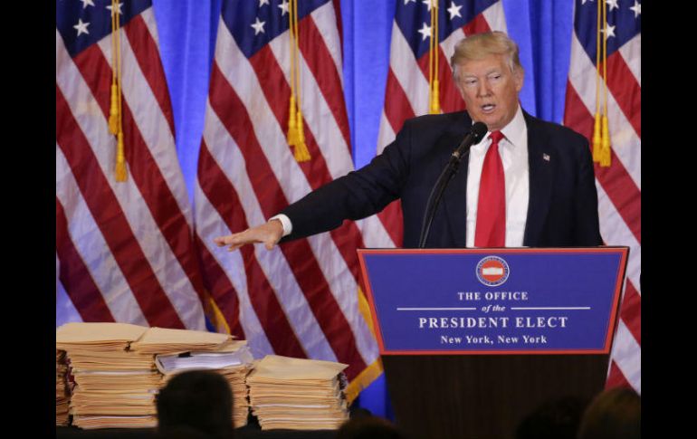 Trump presentó un mueble repleto de sobres con los supuestos documentos que ya firmó para ceder la administración de sus empresas. AP / S. Weing