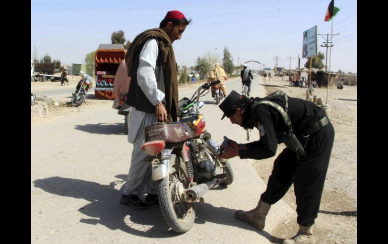 Oficiales de seguridad afgano registran a varios ciudadanos en un puesto de control en Helmand. EFE / W. Yar