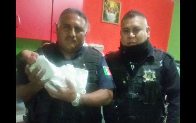 Los oficiales Rogelio (izquierda) y Carlos con el pequeño recién nacido. ESPECIAL / Policía Tlajomulco