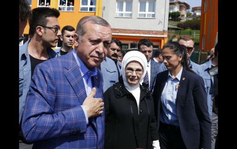 Recep Tayyip Erdogan (i) y su esposa Emin hablan con varios simpatizantes luego de emitir su voto. EFE / S. Suna