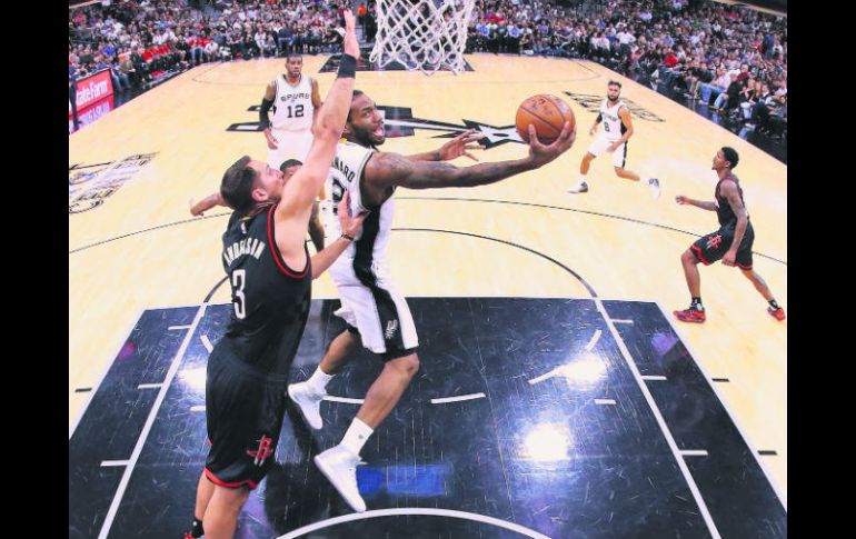 En duda. Kawhi Leonard (con el balón) sumó 22 puntos y 15 rebotes para los Spurs, pero salió lesionado del juego de ayer. AFP /