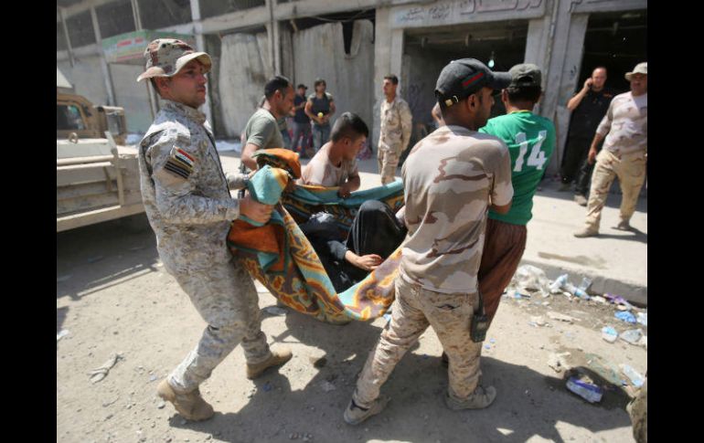 Militares iraquíes trasladan a uno de los heridos en una camilla improvisada al hospital. AFP / A. AL-Rubaye