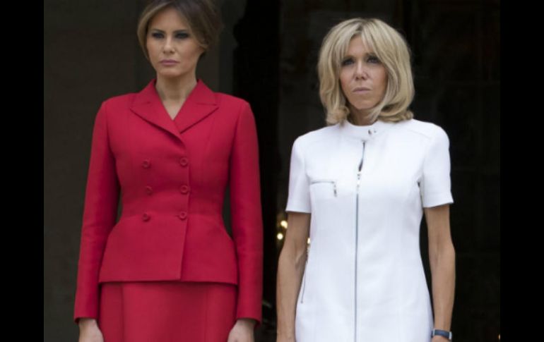 Melania lucía un elegante conjunto de falda y chaqueta rojo Dior y Brigitte Macron llevaba un vestido corto blanco y zapatos azules. EFE / I. Langsdon