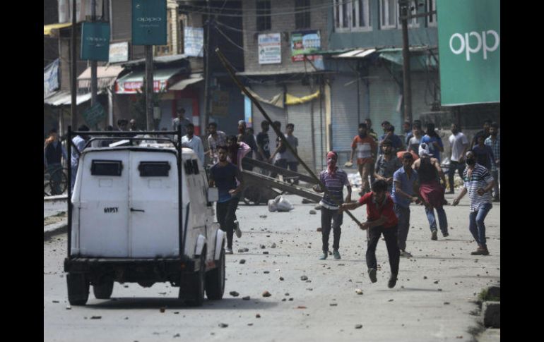 Musulmanes cachemiros atacan a un vehículo de la policía india durante una ola de disturbios. EFE / F. Khan